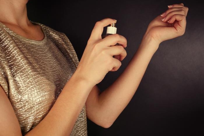 young-woman-applying-perfume-her-wrist